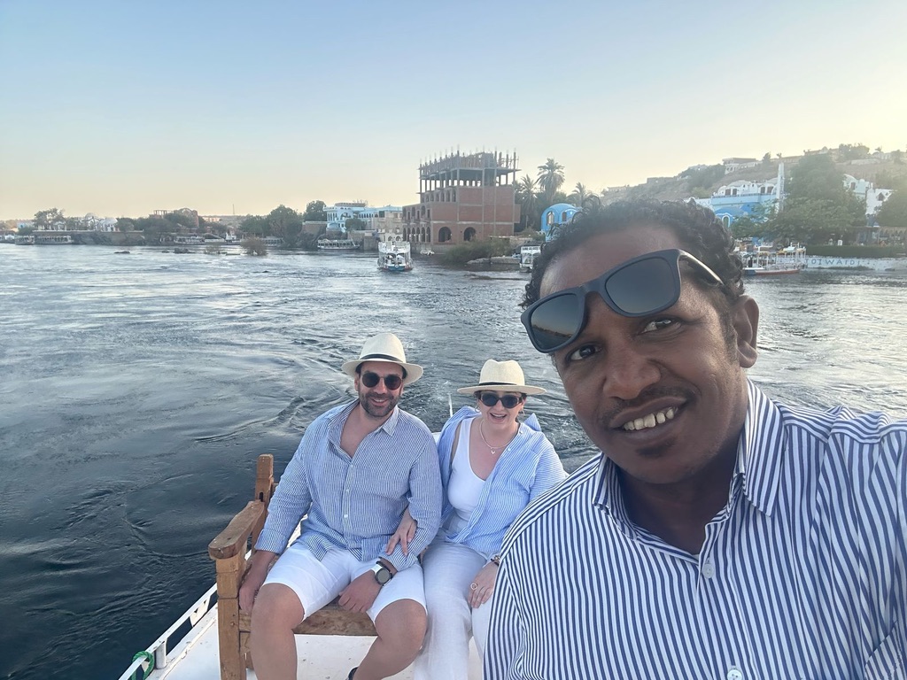 Elegant couple on traditional felucca boat during golden hour on Nile River - romantic experience